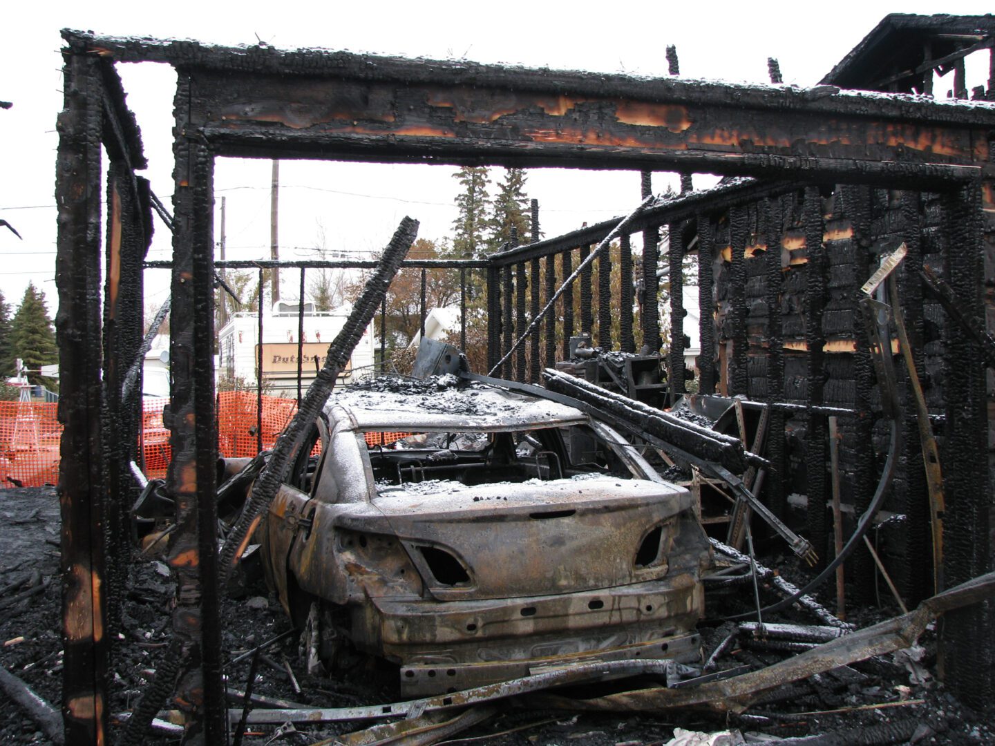 A burned out car in the middle of a building.