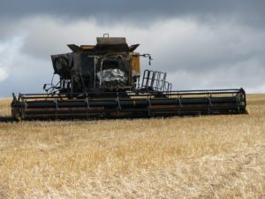 A large yellow and black combine on the field