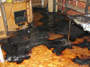 A fire damaged floor with black paint on it.