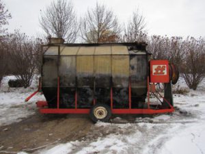 A large black tank sitting on top of snow covered ground.